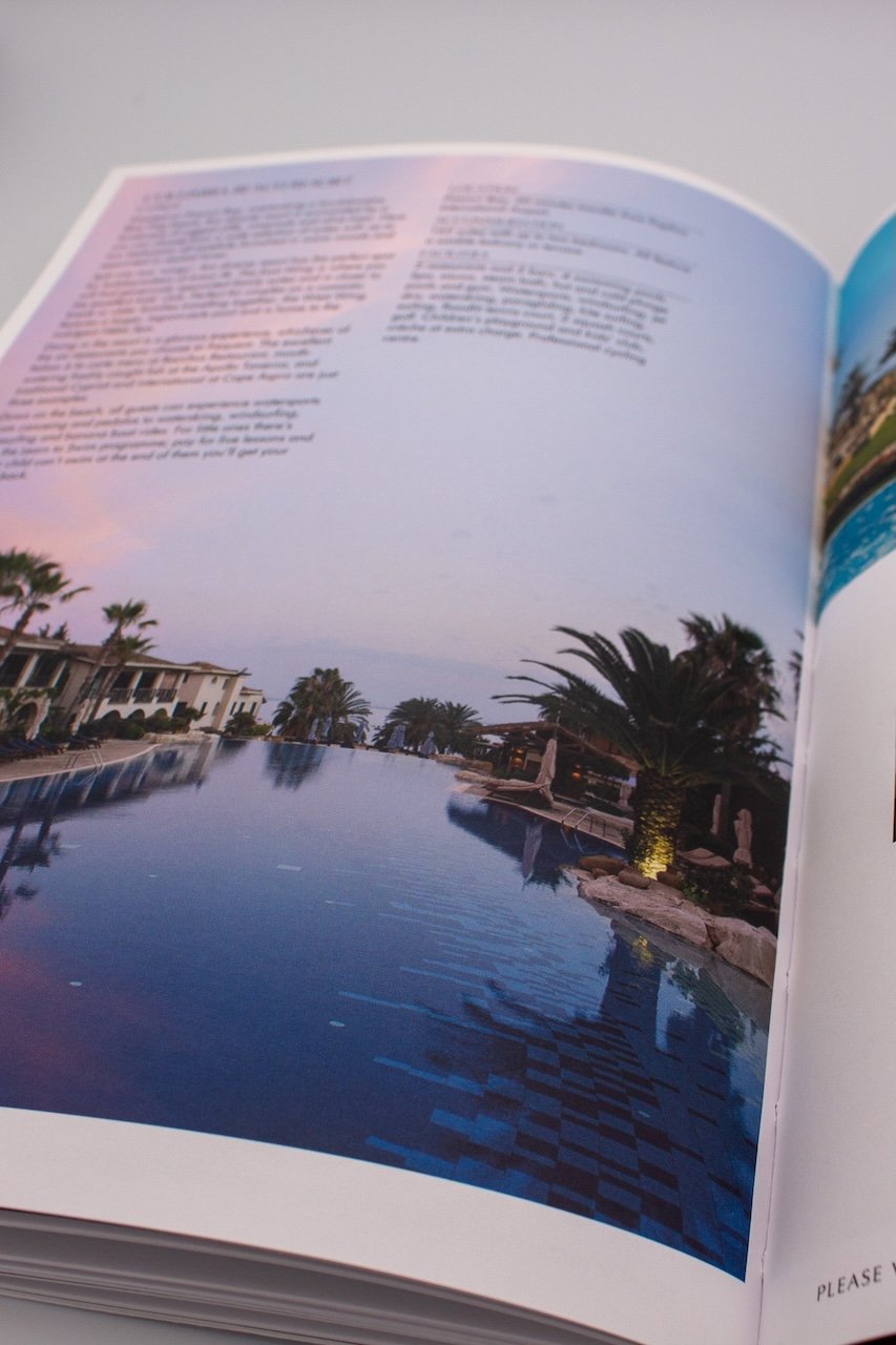 An open travel brochure with a photo of a lake and palm trees