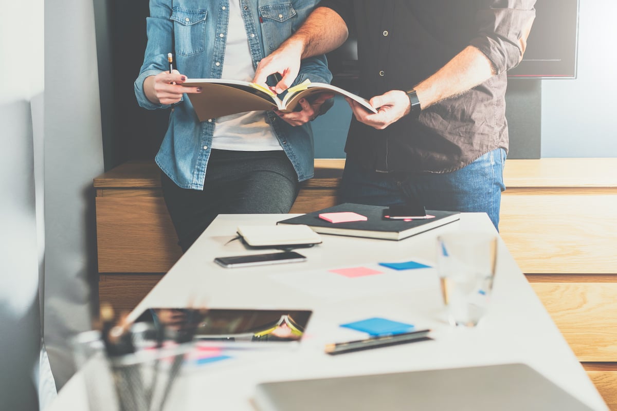 Two people reading a brochure over a table